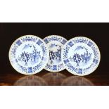 Three Blue & White Delft Chargers decorated with garden scenes within paneled borders with trellis