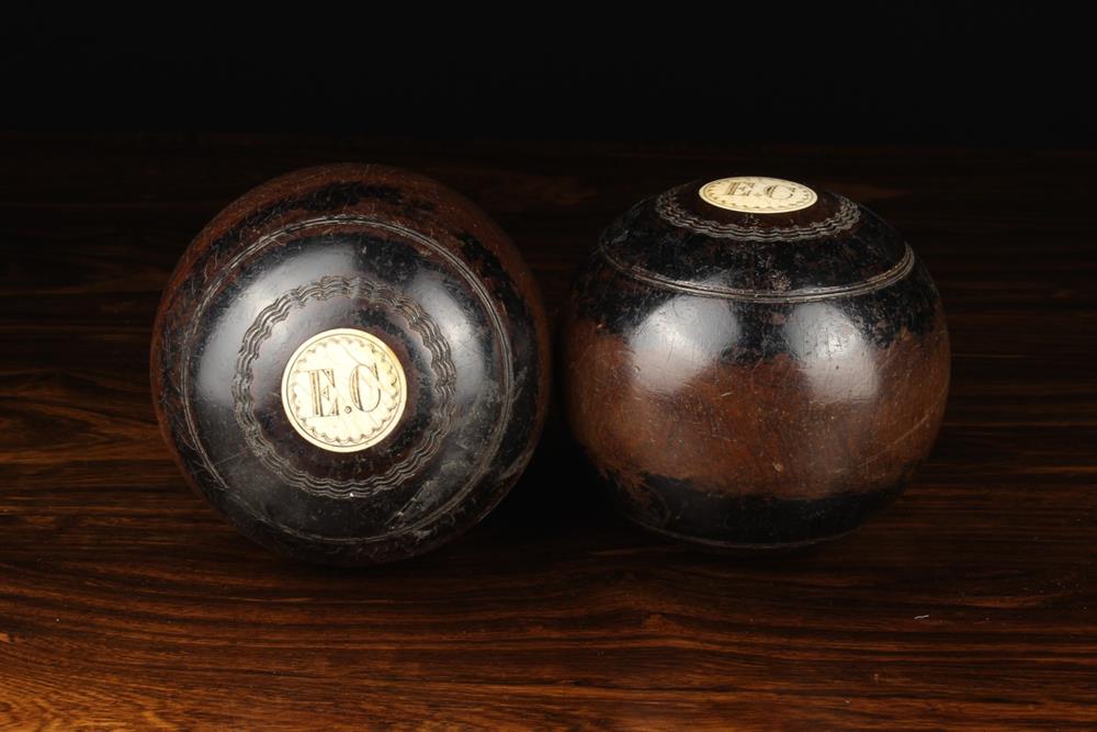 A Pair of Lignum Vitae Bowling Balls labelled '1' and '2' with inset roundels engraved with