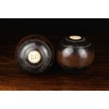 A Pair of Lignum Vitae Bowling Balls labelled '1' and '2' with inset roundels engraved with