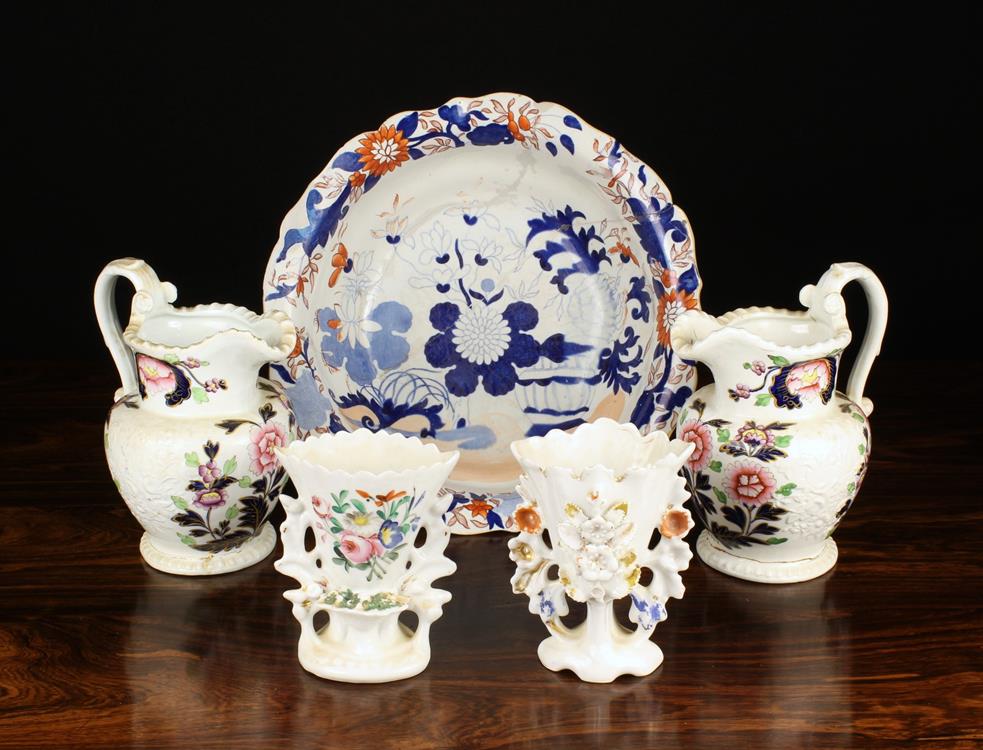 A Pair of Victorian Hard Paste Jugs relief moulded with sprays of flowers either side and enamelled