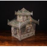 A Vintage Bird-cage composed of elaborately pierced sheet metal with residual paint-work,