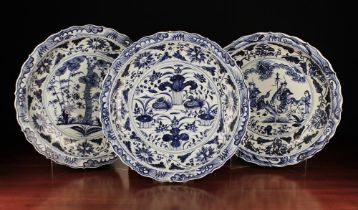 A Set of Three Large Blue & White Chargers with chinoiserie decoration and serpentine borders,