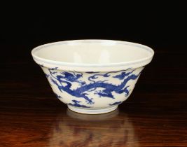 A Chinese Blue & White Bowl decorated with two celestial dragons amongst wispy clouds on a raised