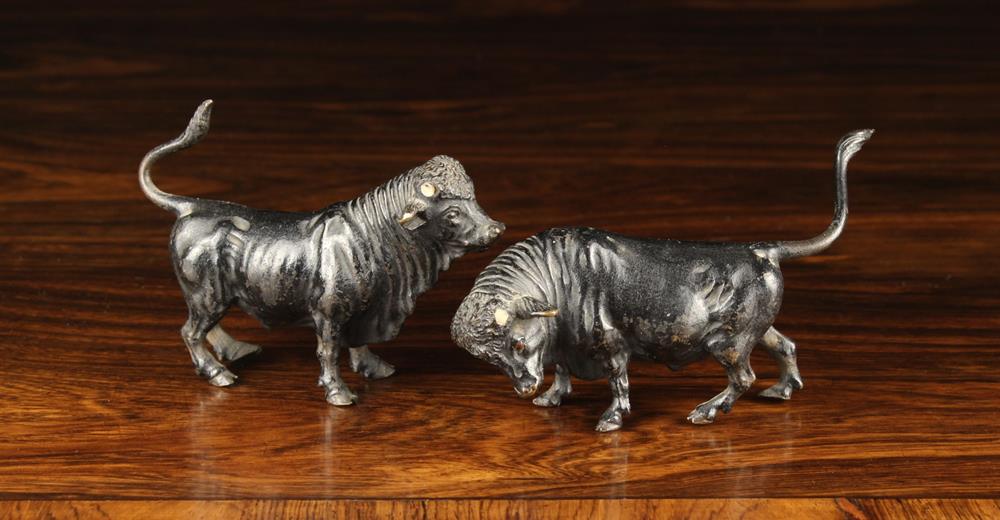 Two Miniature Bronze Bulls with horns removed, 2¾" (7 cm) high, 4" (10 cm) long,