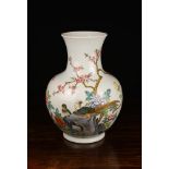 A Chinese Baluster Vase decorated with polychrome enamelled borders perched on rock-work amidst