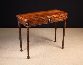 A George IV Fold Over Mahogany Card Table inlaid with ebony bands and mounted with carved lion