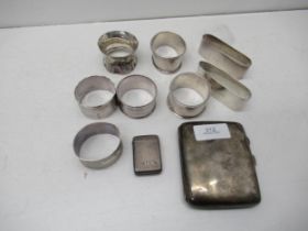 A Victorian silver vesta case, silver cigarette case, and eight silver napkin rings - total weight