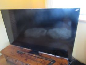 A Samsung flatscreen 65 inch TV together with a Samsung sound bar - in good working order
