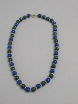 A malachite lapis lazuli 9ct yellow gold bead necklace alternating even sized beads divided with a