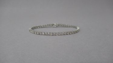 A certificated platinum line bracelet claw-set with round brilliant cut diamonds, with double safety