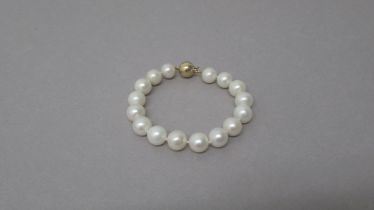 A white cultured pearl bracelet with a 9ct yellow gold ball clasp