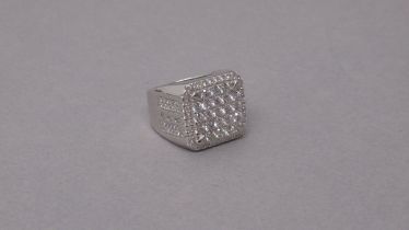 A large silver checkerboard style dinner ring set with several round white cubic zirconia - ring