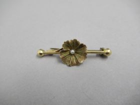 An 18ct yellow gold (tested) bar brooch in the shape of flower with pearl - approx 4.5cm - weight