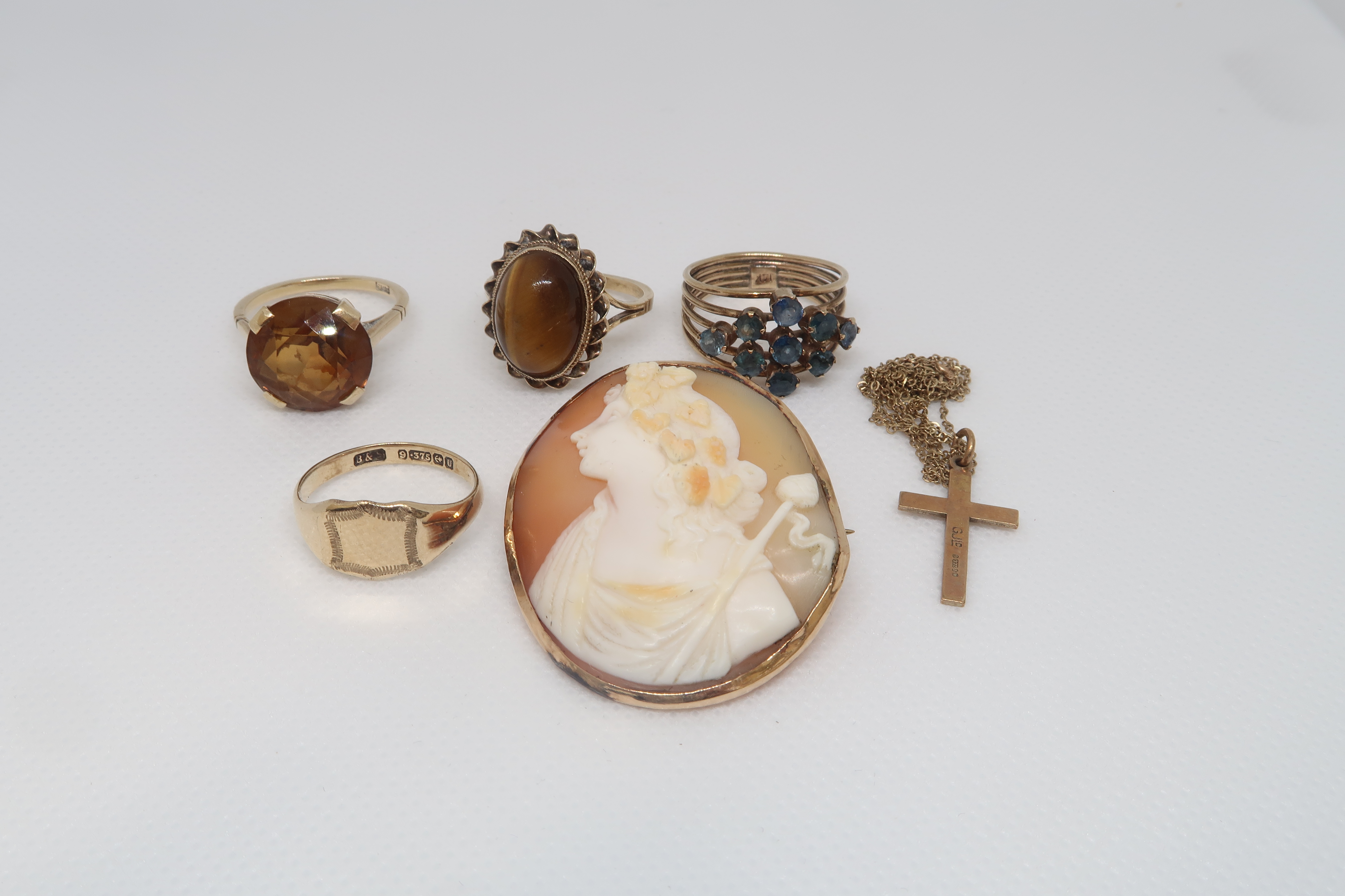 Four gold rings; one 14ct ring and three 9ct rings, all hallmarked, with a 9ct hallmarked cross on a