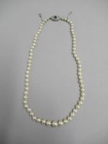 A single string of graduated pearls with 18ct white gold tested sapphire and diamond clasp -