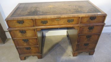 A good quality late 19th century walnut nine drawer knee hole desk with a leather inset top -