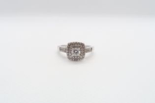 An 18ct white gold and diamond cluster ring - The central round brilliant cut diamond approx 0.