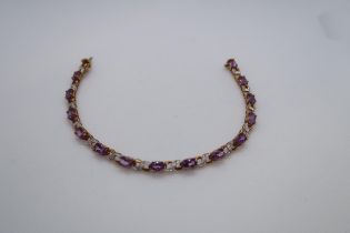 A 9ct yellow gold amethyst and diamond figure of eight bracelet, boxed - Oval cut amethysts 5.50ct