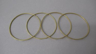 Four yellow gold bangles tested as approx 18ct - diameter approx 6.5cm - approx total weight 27.7