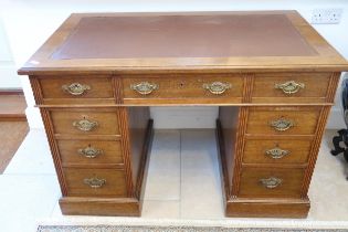 A Victorian oak nine drawer desk with an inset top - Width 116cm x Depth 68cm x Height 66cm