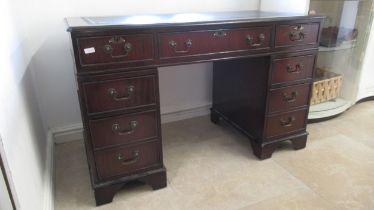 A 20th century mahogany nine drawer desk with an inset top - Width 120cm x Depth 57cm