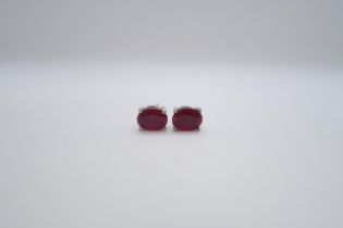 A pair of treated ruby studs set in silver
