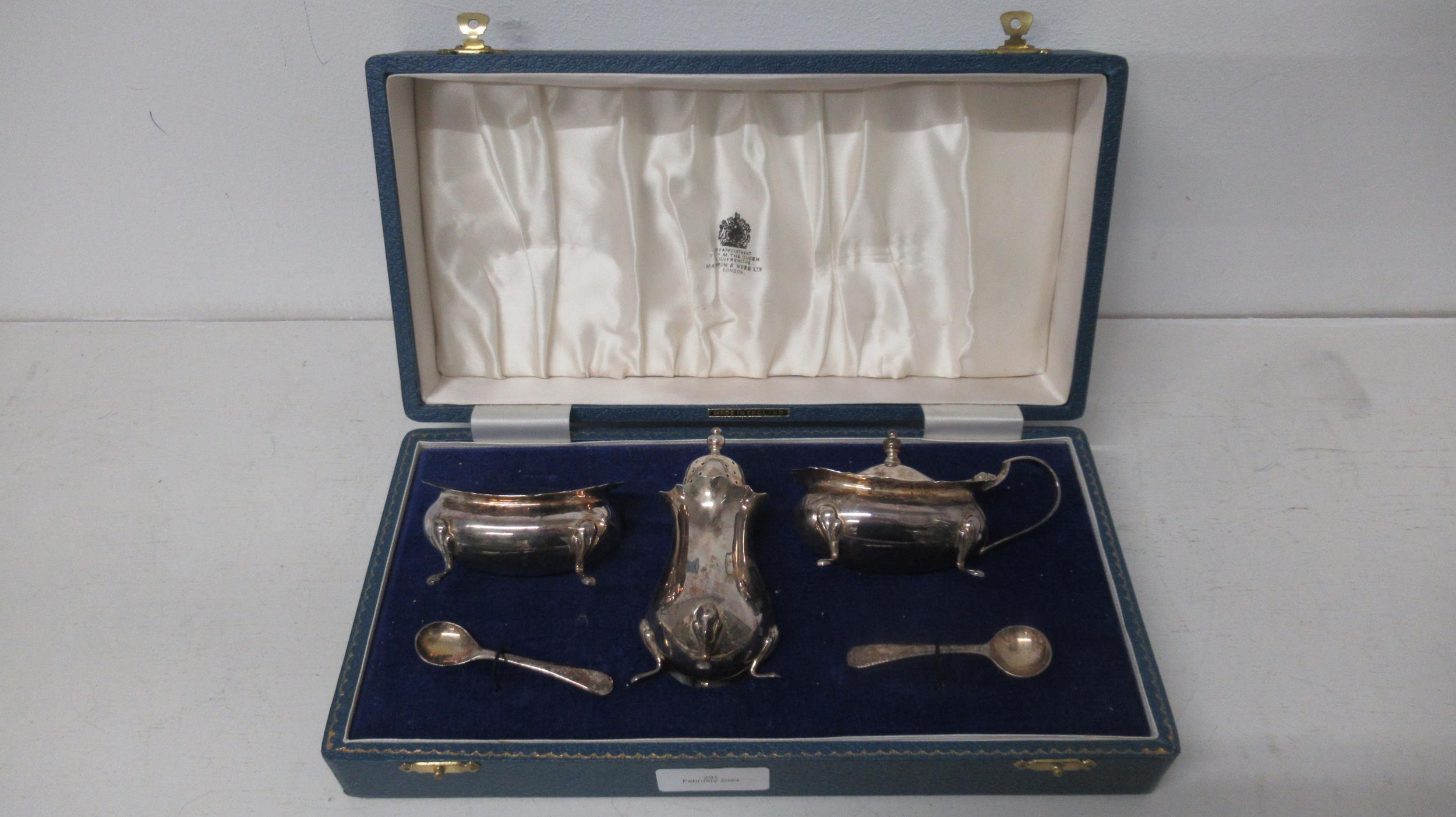 A silver three piece condiment set Mappin & Webb, Birmingham 1969 with blue glass liners in matching