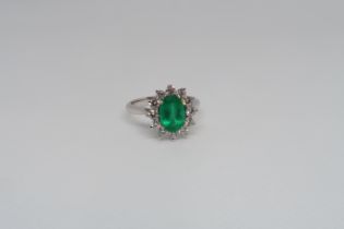 A good platinum (hallmarked) emerald and diamond cluster ring - the central oval emerald approx 1.