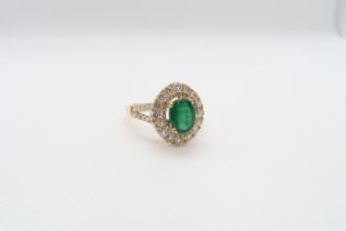 A very good 18ct yellow gold (hallmarked) emerald and diamond ring - the central oval emerald approx