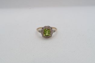 A 9ct yellow gold Peridot and diamond ring with diamond shoulders - head size approx 11mm x 11mm -