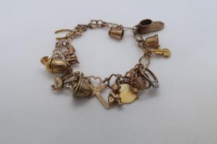 A 9ct (hallmarked) charm bracelet - 13 charms - approx weight 26 grams