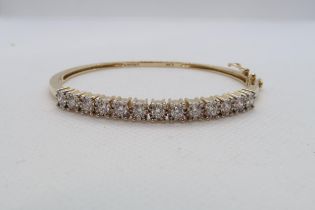 A diamond set hinged bangle, round brilliant cut diamonds set in 14k (hallmarked) yellow gold with