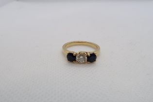 An 18ct yellow gold (hallmarked) three stone diamond and sapphire ring with accompanying insurance