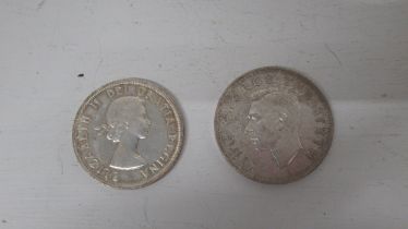 Two silver coins: 1959 .800 silver dollar Canada, and 1949 .500 silver crow New Zealand