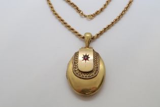 A Victorian yellow gold locket with red garnet, 6cm, with ring, on 9ct yellow gold hallmarked chain,