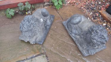 A pair of cast reconstituted stone recumbent lions on rectangular bases - Length 41cm x Width 27cm