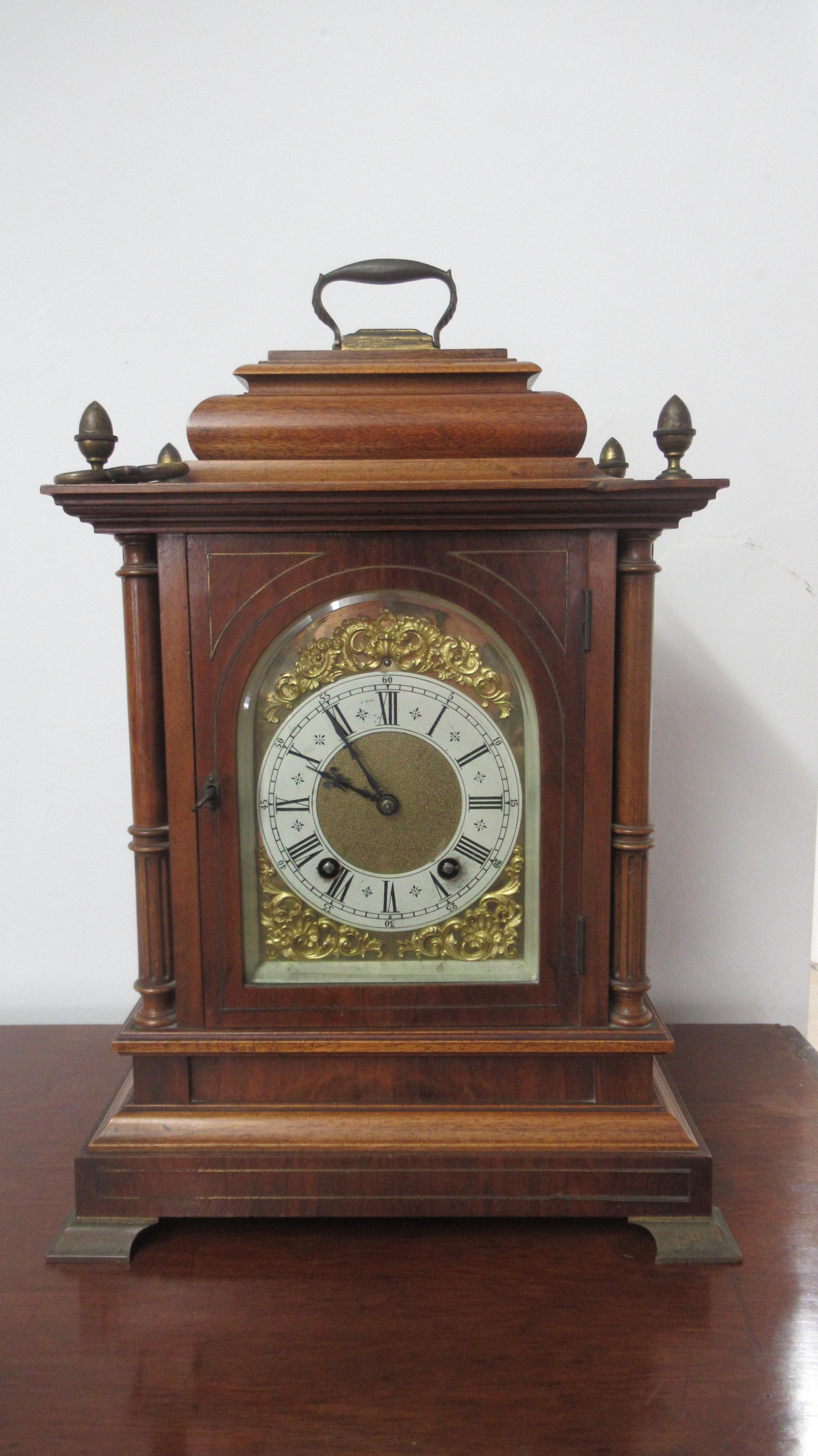 A Lenzkirch mahogany architectural 8 day mantel clock with brass dial on four brass feet with