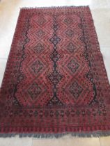 An Afghan red ground hand knotted rug - 195cm x 120cm