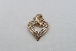 A 14ct yellow gold (hallmarked) heart shaped pendant set with round and baguette diamonds - approx