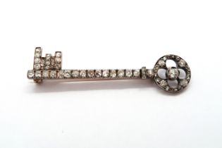 A late Victorian diamond brooch in the shape of a key - old cut diamonds set in white and yellow