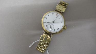 An 18ct vintage gents wristwatch with a gold plated strap with a seconds hand - in working order