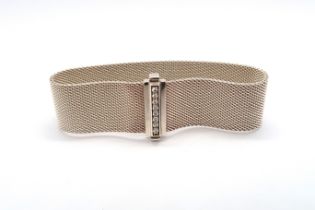 A Tiffany & Co signed sterling silver satin finish band bracelet with a row of diamonds set to the