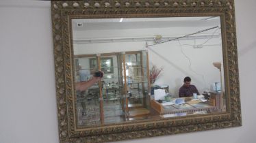 A modern carved pine mirror with bevelled glass - 112cm x 81cm