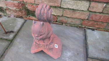 A roof ridge finial of a squirrel on a 90 degree tile - Width 24cm x Depth 18cm x Height 41cm