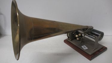 A phonograph with a brass witches horn and a large quantity cylindrical music cylinders, movement in