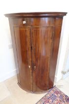 A Georgian mahogany box fronted corner cupboard with three interior shelves