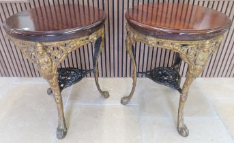 A pair of cast iron circular pub tables with polished tops and painted bases