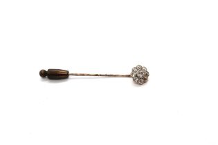 A diamond daisy cluster tie pin - the central old cut diamond surrounded by eight smaller diamonds -