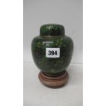 A green enamel ginger jar on stand