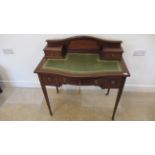 An Edwardian mahogany and inlaid bow fronted ladies writing desk with a leather inset top over three